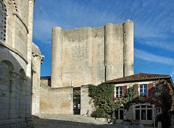 Una parte de torre con piedra clara y de fondo el cielo.
