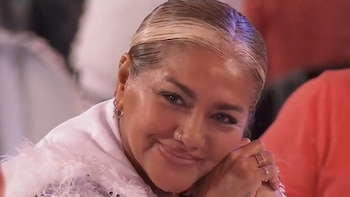 Primer plano de Gladys La Bomba Tucumana sonriendo. Tiene el cabello rubio platinado recogido, un piercing en la nariz y anillos en los dedos. Viste una prenda blanca