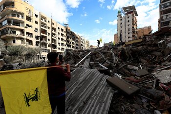 La gente lleva banderas de Hezbolá en un lugar dañado en los suburbios del sur de Beirut, después de que entrara en vigor un alto el fuego entre Israel y Hezbolá, en Beirut, Líbano, el 27 de noviembre de 2024. REUTERS/Thaier Al-Sudani
