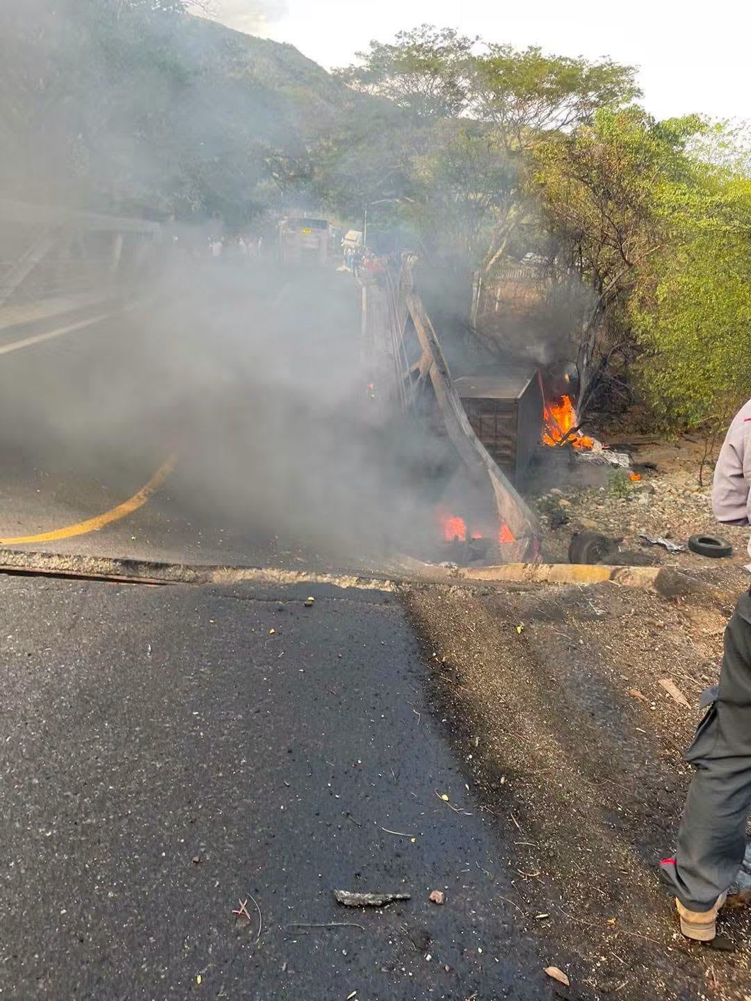 Un camión accidentado se incendia a un costado de una carretera de montaña mientras emite una densa columna de humo. (La noche informativa)