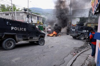 Vehículos policiales pasan junto al