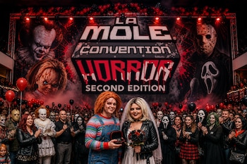 Un hombre y una mujer disfrazados de Chucky y Tiffany posan ante un público con un gran letrero de La Mole Convention Horror al fondo.