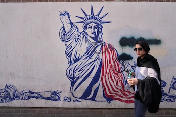 Una mujer pasa junto a un mural antiestadounidense en la pared de la antigua embajada de Estados Unidos, ahora convertida en museo, en Teherán, Irán, el viernes 12 de junio de 2026. (Foto AP/Vahid Salemi)