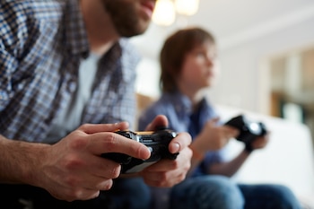 Padre e hijo jugando a videojuegos (Magnific)
