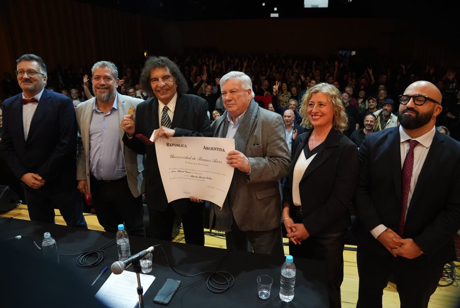 Junto a autoridades académicas, Alejandro Dolina exhibe su diploma de doctor honoris causa otorgado por la Universidad de Buenos Aires