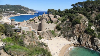 El castillo de Tossa de Mar junto a la playa desde un sendero (Visita Costa Brava)