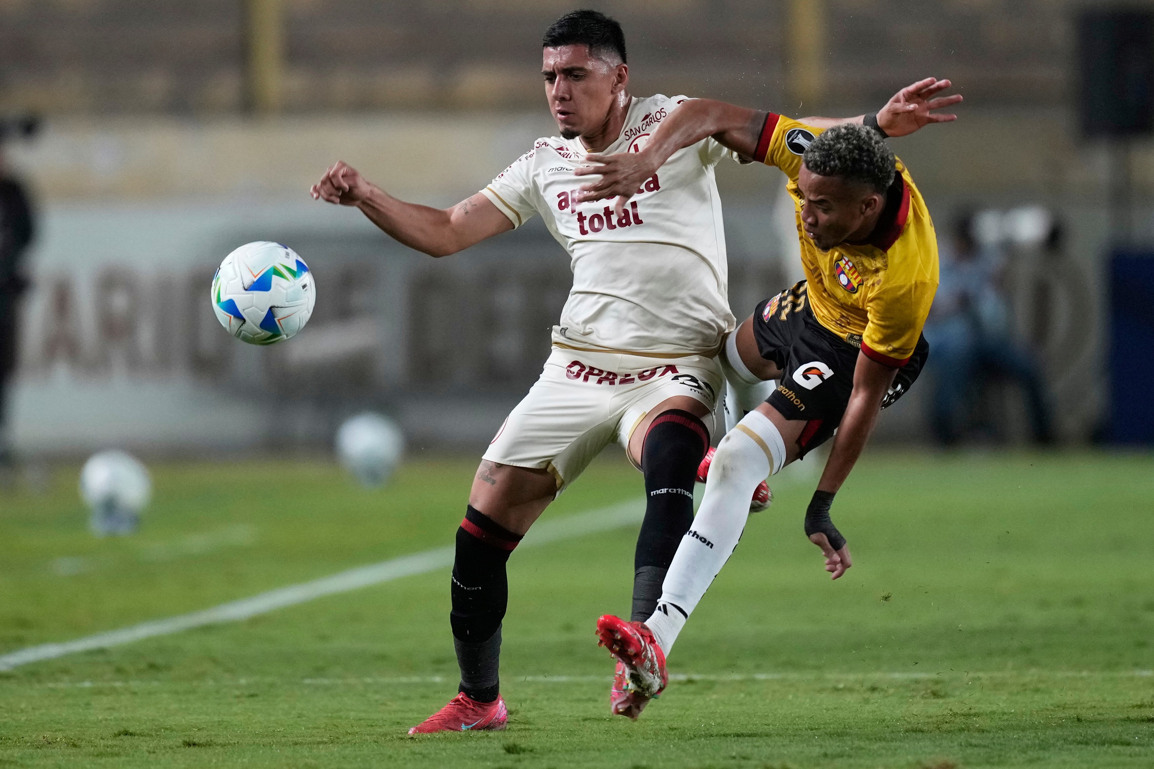 Byron Castillo del Barcelona de Ecuador pelea por el balón con César Inga del Universitario de Perú en el Grupo B de la Copa Libertadores el miércoles 14 de mayo del 2025. (AP Foto/Martin Mejia)