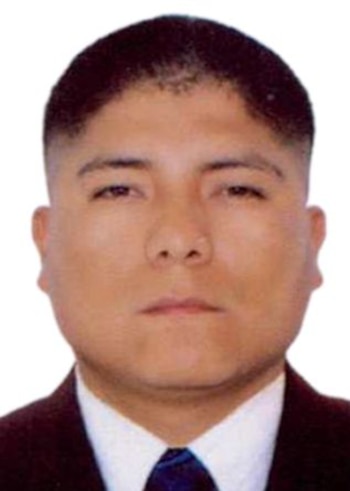 Retrato de frente de un hombre con cabello corto, traje oscuro, camisa blanca y corbata azul sobre un fondo blanco