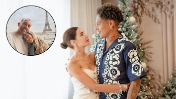 Un hombre y una mujer se abrazan en un interior festivo junto a una imagen circular de otra pareja con la Torre Eiffel detrás