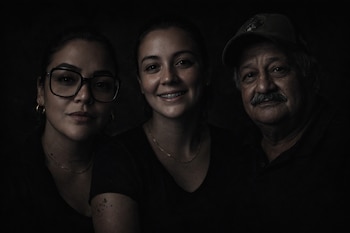 Una mujer con gafas, una mujer con frenillos, y un hombre con bigote y gorra en primer plano.