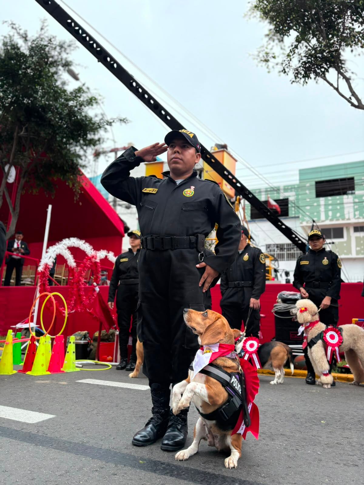 Un oficial de la Policía Nacional del Perú junto a un perro de la unidad canina rinden honores en el Desfile y Parada Militar por Fiestas Patrias en la Avenida Brasil.