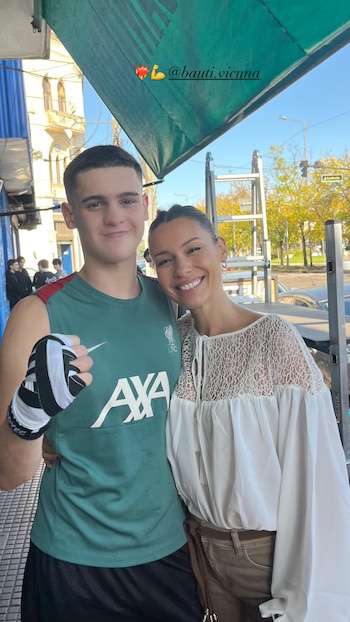 Pampita y Bautista Vicuña sonríen. Él, a la izquierda, viste camiseta verde de tirantes y muestra vendaje de boxeo. Ella, a la derecha, lleva blusa blanca de encaje