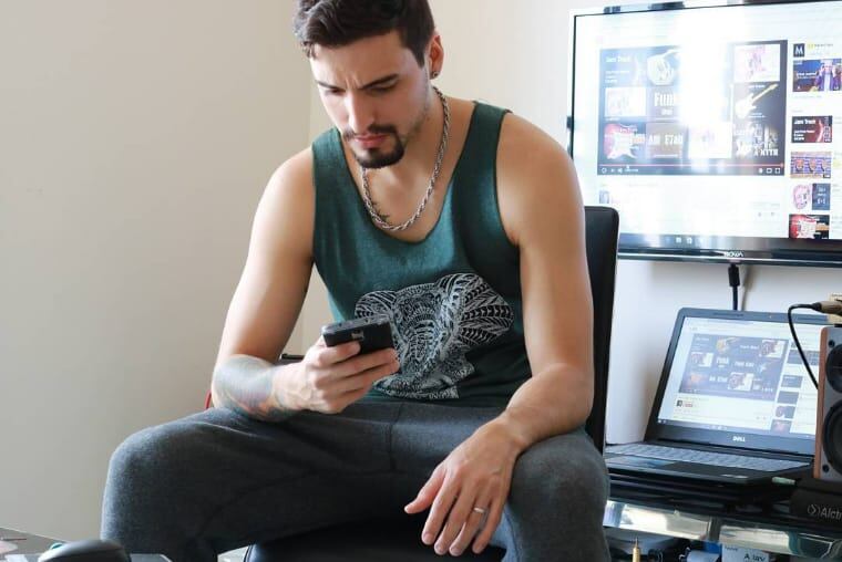 El venezolano residenciado en Ucrania, Guillermo López, leyendo en su celular