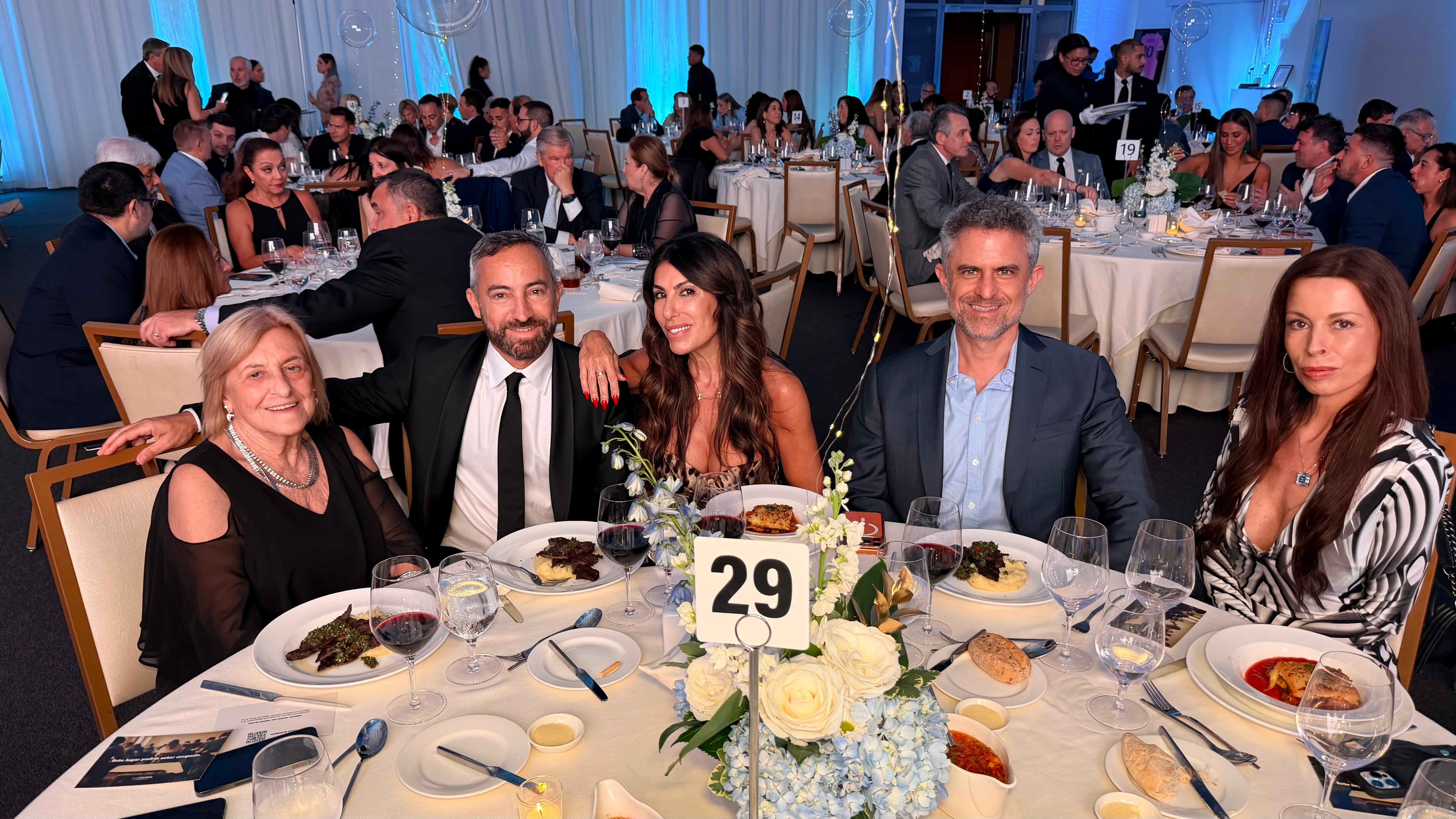 María Ester Graciano, Leandro Barbuscio, Judith Hofman, Damian Najman y Karina Delonga posan sonrientes en la mesa 29 durante la cena de la Cámara Argentino-Americana de Comercio