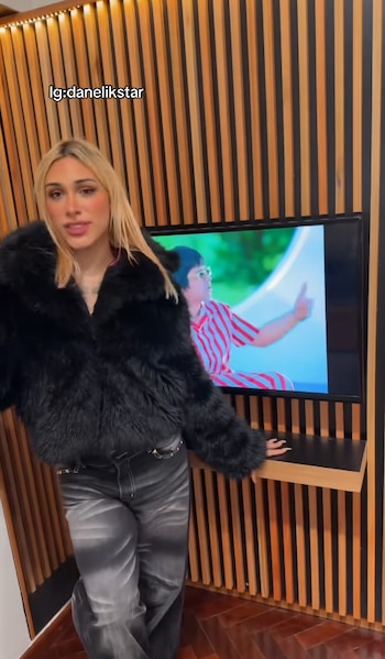 El departamento de Belgrano tiene living con televisor y sillón cama, comedor con mesa blanca y una cocina separada por una barra
