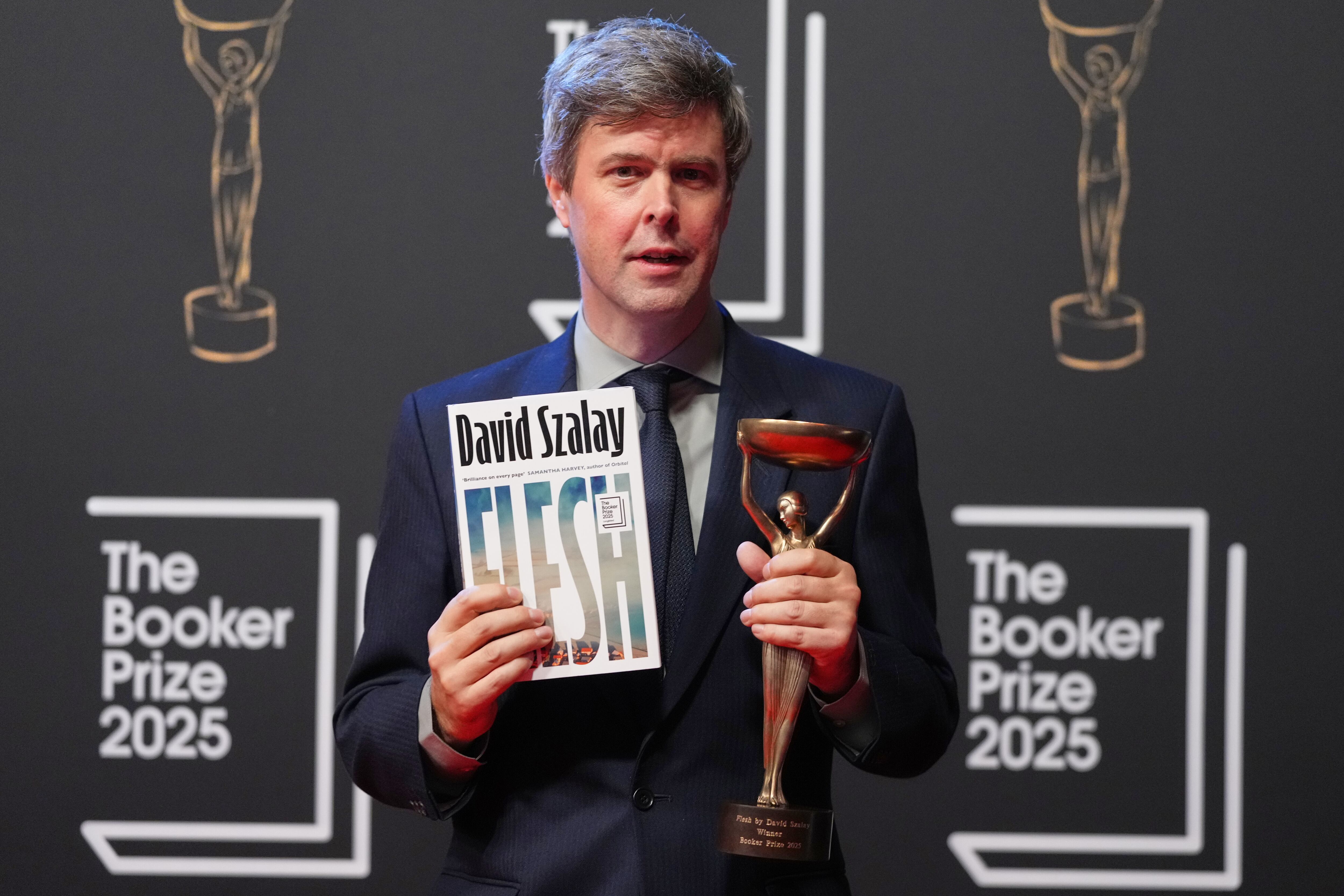 El autor húngaro-británico David Szalay posa para los fotógrafos con el trofeo tras ganar el Premio Booker 2025 por su libro 'Flesh' (AP Photo/Kirsty Wigglesworth)