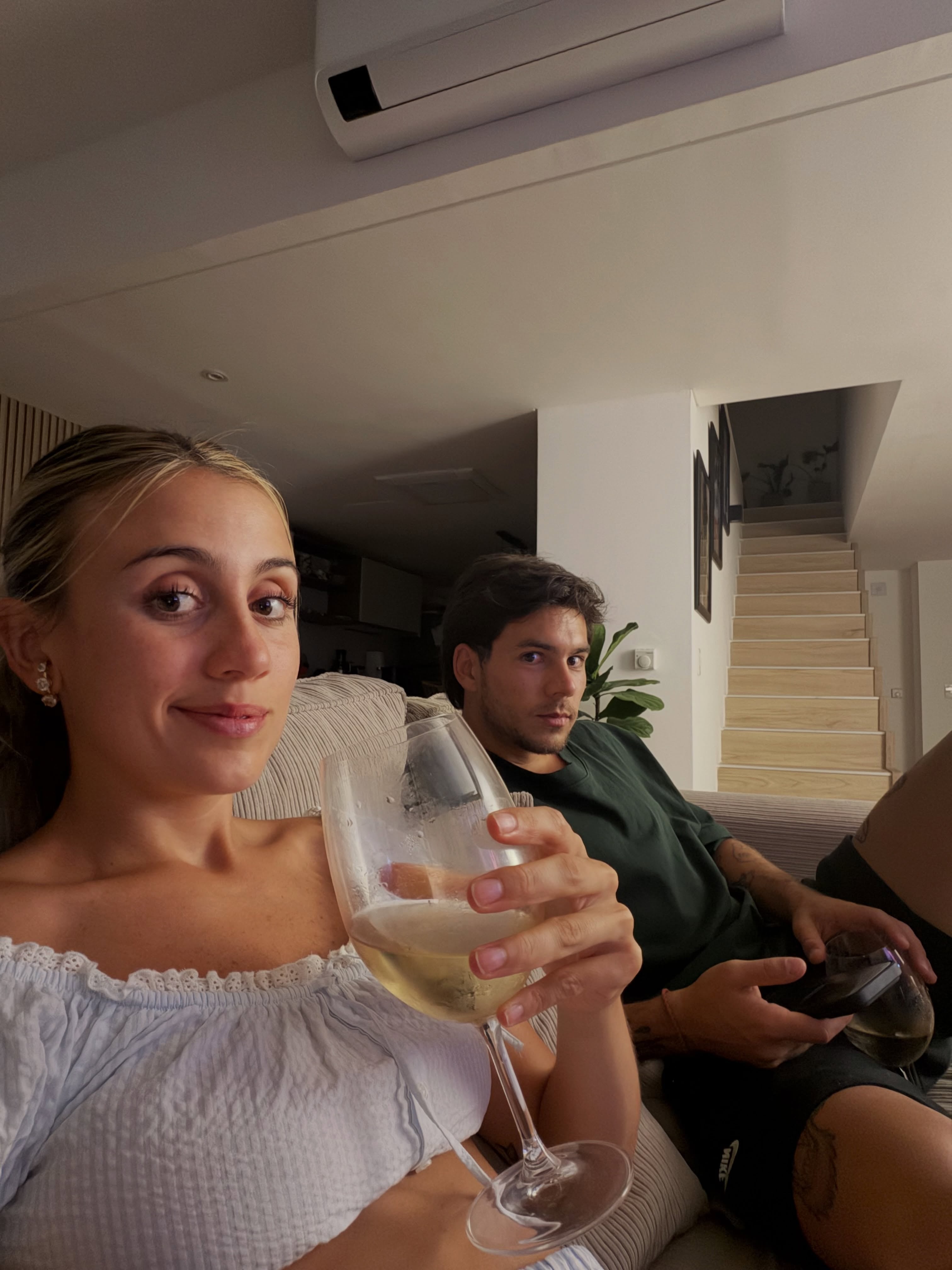 La periodista Morena Beltrán se toma una fotografía junto al futbolista Lucas Blondel en la sala de una casa.