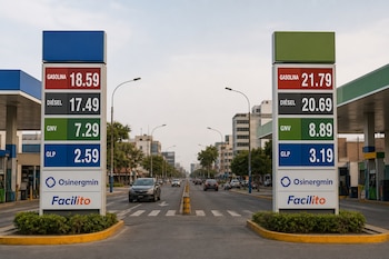 Dos letreros de precios de combustible frente a una avenida muestran valores de gasolina, diésel, GNV, GLP y el logotipo de Osinergmin.