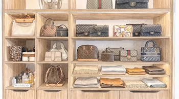 Ilustración de estantes de madera con bolsos de diseñador, frascos de perfume, un cartel pequeño y prendas de tela dobladas.