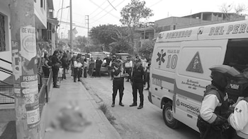 Agentes policiales y una ambulancia estacionada en una calle de Villa El Salvador mientras varias personas observan desde la acera