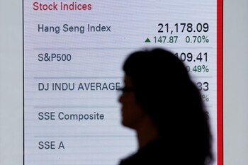 Foto de archivo. Una mujer camina frente a un panel que muestra los índices bursátiles de los mercados de Hong Kong, Estados Unidos y China, fuera de un banco en Hong Kong. 7 de junio de 2016. REUTERS/Bobby Yip.