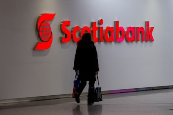 FILE PHOTO: A person walks past a sign for The Bank of Nova Scotia, operating as Scotiabank, in Toronto, Ontario, Canada December 13, 2021. REUTERS/Carlos Osorio/File Photo