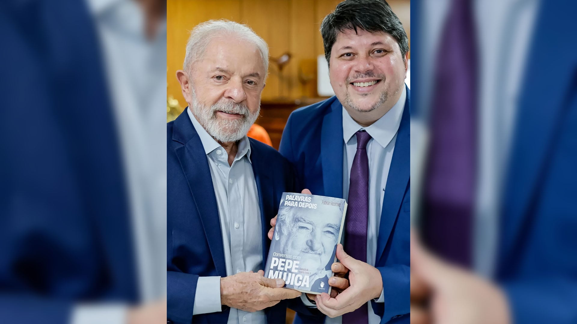 El activista brasileño Rogerio Tomaz posa junto al presidente Luiz Inácio Lula da Silva mientras sostienen un libro sobre Pepe Mujica.