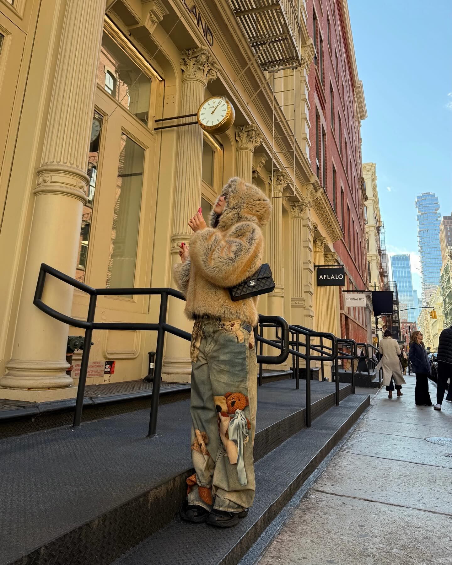 Apostando al glamour urbano, la artista posó frente a un edificio clásico de la ciudad con abrigo, gafas y capucha