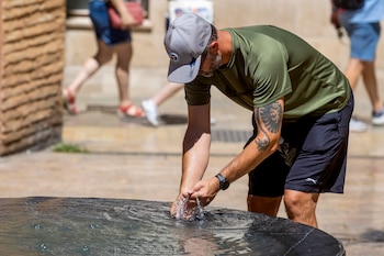 Un hombre se refresca en el centro histórico de Málaga este mediodía. (EFE/Álvaro Cabrera)