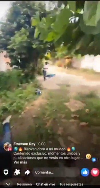 Captura de pantalla de un video en directo que muestra un camino de tierra entre vegetación con personas al fondo y texto superpuesto