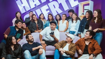 Jorge Luna, vistiendo camiseta blanca y gorra, sostiene un premio negro Effie Plata, rodeado de su equipo sonriente frente a una pared morada