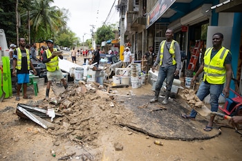 Personal municipal recoge escombros, en Las 800, un barrio humilde en Santo Domingo (República Dominicana), que ha sufrido graves inundaciones a causa de las torrenciales lluvias arrojadas por una vaguada que incide sobre gran parte del país. (EFE/Orlando Barría)