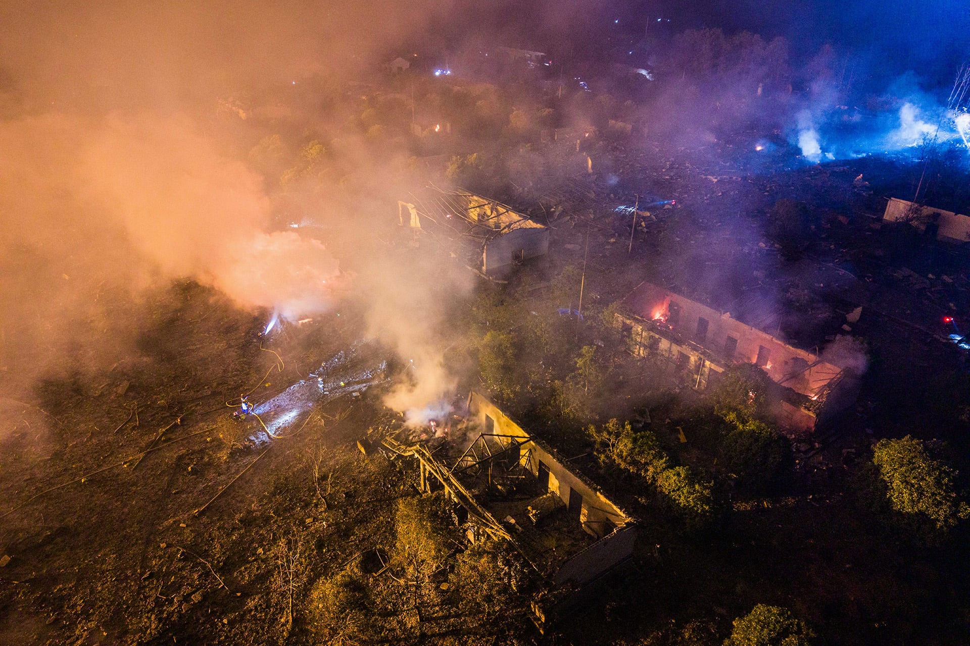 Vista aérea nocturna muestra la devastación y múltiples incendios activos en las instalaciones de 华盛烟花制造燃放公司 tras una fuerte explosión. (AP News)