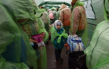Ukrainian refugees shelter in a tent as they wait in line to cross the Ukraine-Poland border, after fleeing the Russian invasion of Ukraine, outside the border crossing checkpoint in Shehyni, Ukraine, March 31, 2022. REUTERS/Hannah McKay
