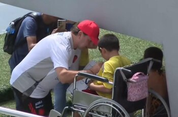 Néstor Lorenzo autografiando la camisa a un niño