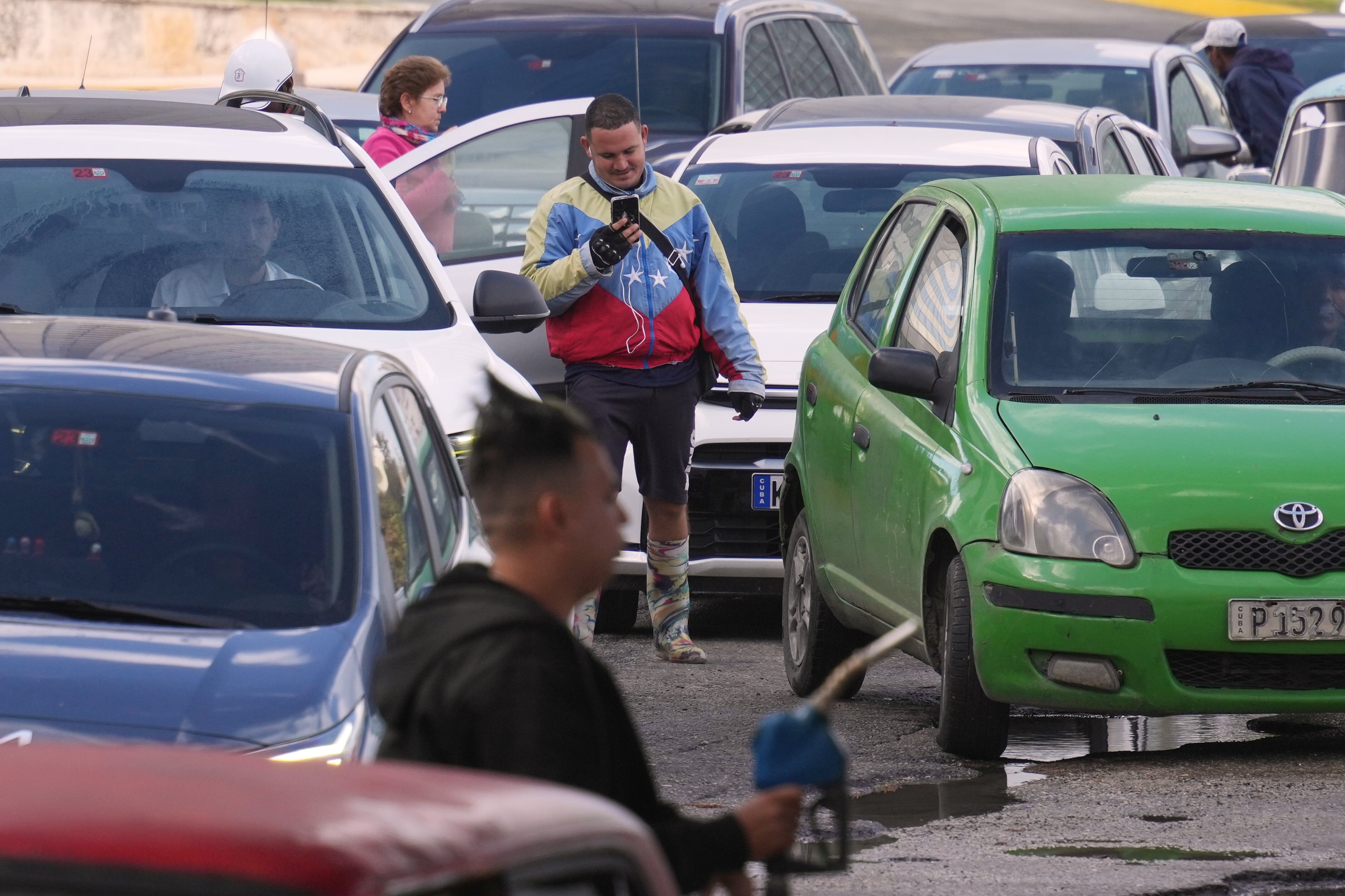 Un hombre con una chaqueta con los colores de la bandera de Venezuela hace fila para comprar combustible en una gasolinera, el viernes 6 de febrero de 2026, en La Habana, Cuba (AP Foto/Ramón Espinosa)
