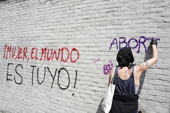 Una mujer pinta una pared