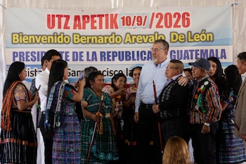 Bernardo Arévalo posa junto a personas con indumentaria indígena ante una pancarta de bienvenida en Guatemala