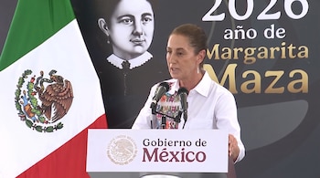 Mujer de cabello recogido hablando frente a dos micrófonos en un podio con el escudo de México, bandera nacional y fondo con retrato de Margarita Maza y texto 2020.