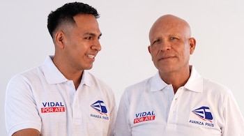Dos hombres con camisetas polo blancas que llevan el logotipo de Avanza País y el texto Vidal por Ate posan sobre fondo blanco.