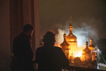 El obispo Avraamiy, a la derecha, de la Lavra de Kiev-Pechersk de la Iglesia Ortodoxa de Ucrania, observa la catedral de la Dormición de la Lavra de Kiev-Pechersk, también conocida como el Monasterio de las Cuevas, en llamas durante un ataque ruso contra Kiev, Ucrania, el lunes 15 de junio de 2026. (Foto AP/Evgeniy Maloletka)