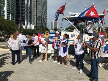 Manifestantes esperan hoy la llegada de una caravana de vehículos en apoyo de la marcha cívica por el cambio en Cuba, en la dársena situada en la bahía de Vizcaya en Miami (Florida, EE.UU.). EFE/Ana Mengotti