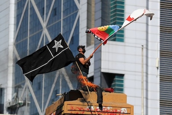 Un manifestante ondea una bandera durante una protesta contra el gobierno de Chile en el segundo aniversario de las protestas y disturbios que sacudieron la capital en 2019, en Santiago, Chile, el 18 de octubre de 2021.. REUTERS/Ivan Alvarado