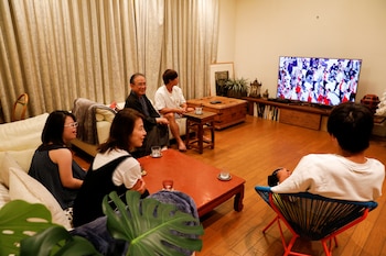 Masatsugu Kobori (61), Hideko Kobori (54), and their children Masataka (21), Masayasu (18) and Noriko (13), watch the Tokyo 2020 Olympics Opening Ceremony on TV at home on the day of the start of the Tokyo 2020 Olympics in Tokyo, Japan July 23, 2021 REUTERS/Androniki Christodoulou