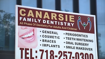 Cartel blanco y marrón de Canarsie Family Dentistry, con una lista de servicios, número de teléfono, boca sonriente y logo familiar