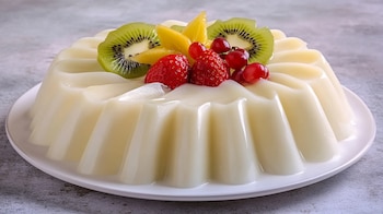 Postre de gelatina de tres leches con frutas tropicales: kiwi, fresas, uvas verdes y carambola, presentación fresca y llamativa. - (Imagen Ilustrativa Infobae)