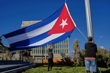 Trabajadores ondean la bandera cubana