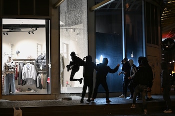Jóvenes rompen el escaparate de una tienda durante enfrentamientos entre manifestantes y policías en País, el domingo 18 de octubre de 2026. (AP Foto/Emma Da Silva)
