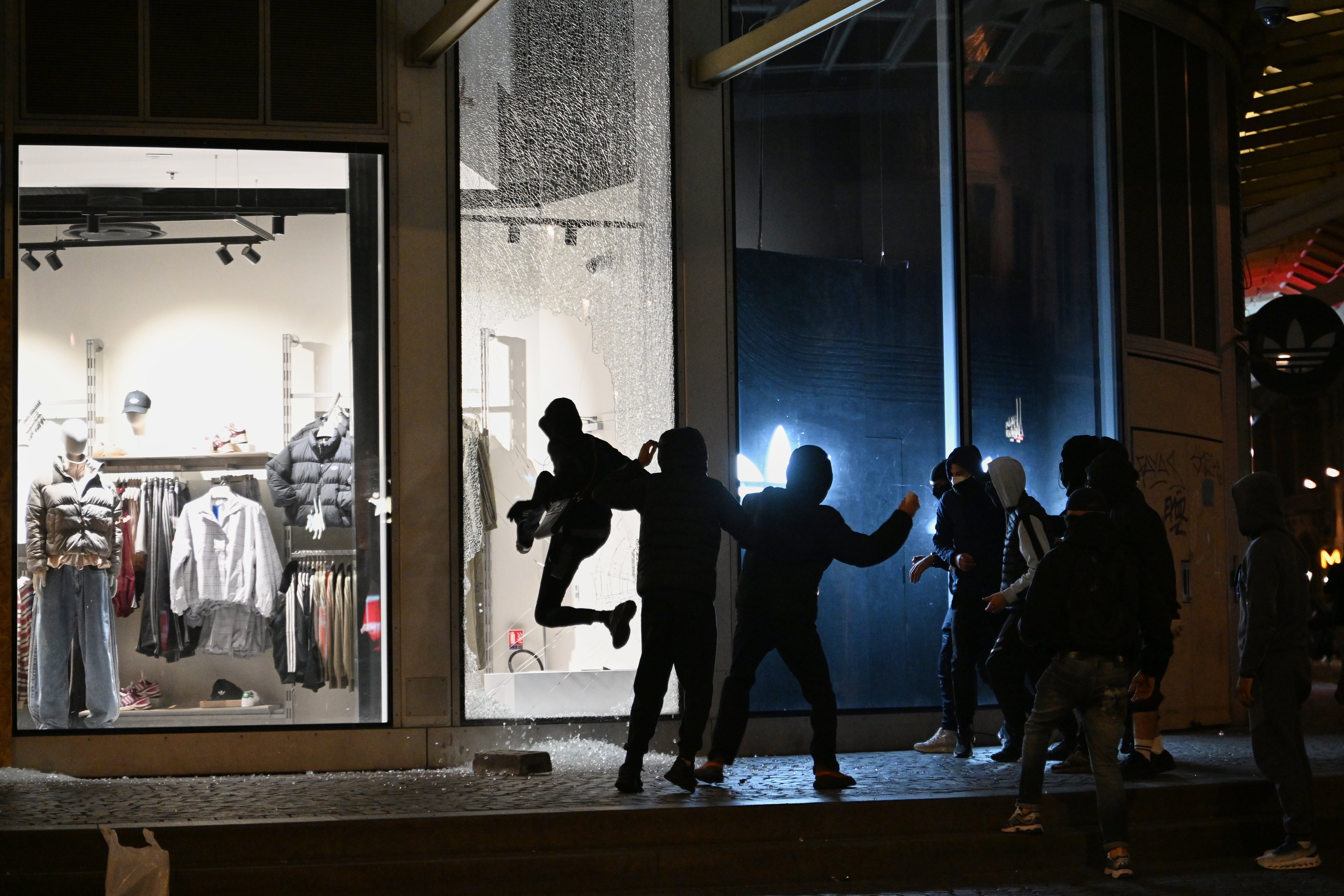 Jóvenes rompen el escaparate de una tienda durante enfrentamientos entre manifestantes y policías en País, el domingo 18 de octubre de 2026. (AP Foto/Emma Da Silva)