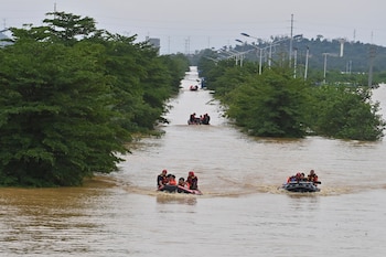 En esta imagen publicada por la agencia de noticias Xinhua, rescatistas evacúan profesores y alumnos varados en un recinto educativo de Xijiang tras el paso de la tormenta tropical Maysak en la ciudad de Guigang, en la región autónoma china de Guangxi, el 8 de julio de 2026. (Zhou Hua/Xinhua via AP)